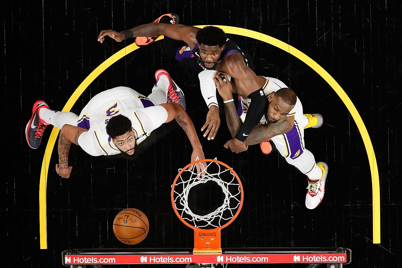 Russell Westbrook will need to take a back seat at the Lakers, who also have superstars Anthony Davis (left) and LeBron James (right, tussling with Phoenix's Deandre Ayton during a game in May).