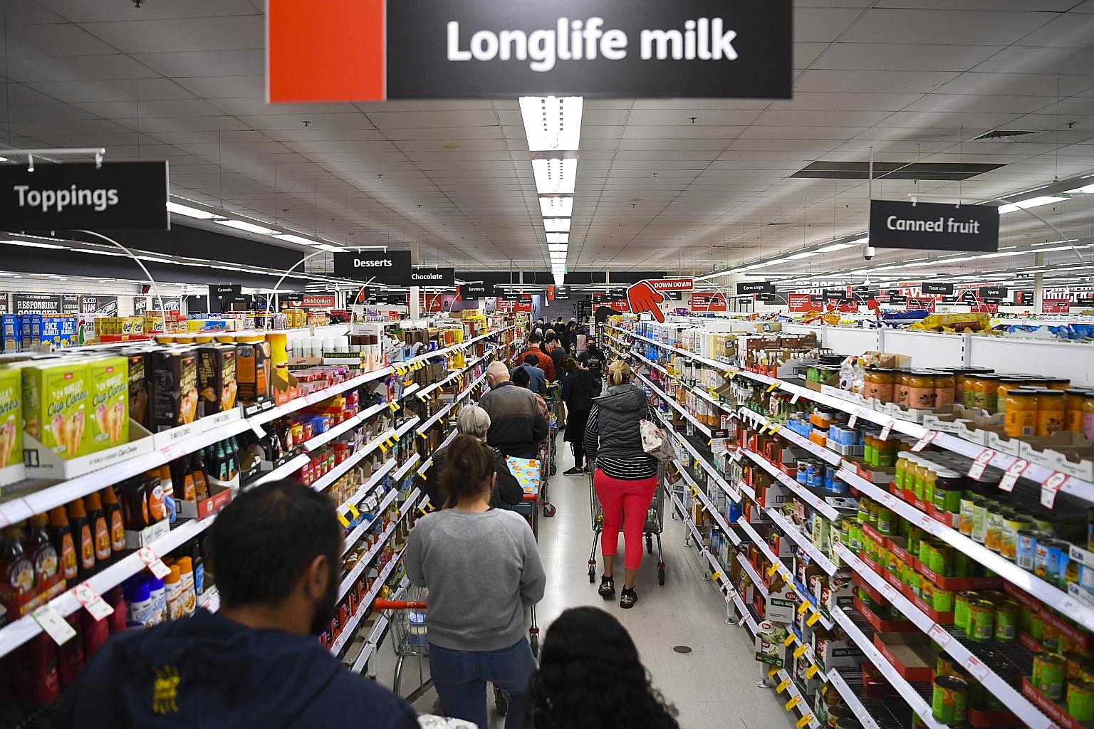Long queues at a supermarket in the Woden area in Canberra, Australia, yesterday. About 400,000 people were subjected to stay-at-home orders from 5pm local time yesterday as the capital began a seven-day lockdown. PHOTO: EPA-EFE
