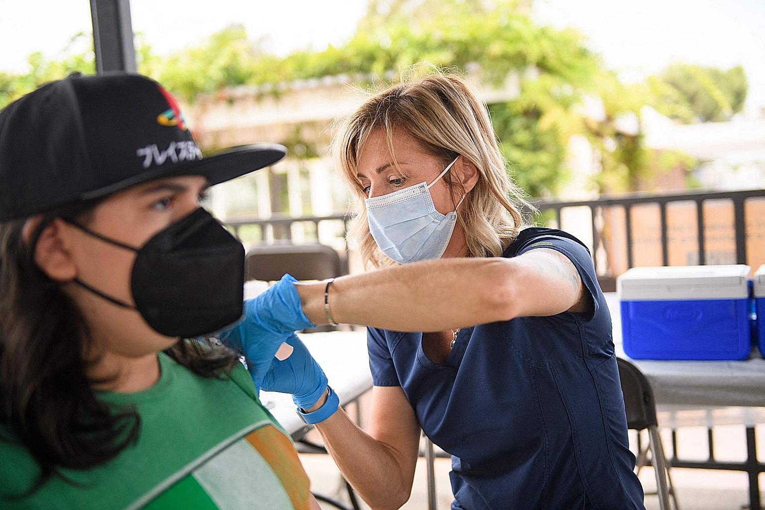 A nurse administering a dose at a mobile vaccination clinic at the California State University Long Beach campus on Thursday. The state's largest teachers' union said it supports the vaccination mandate.