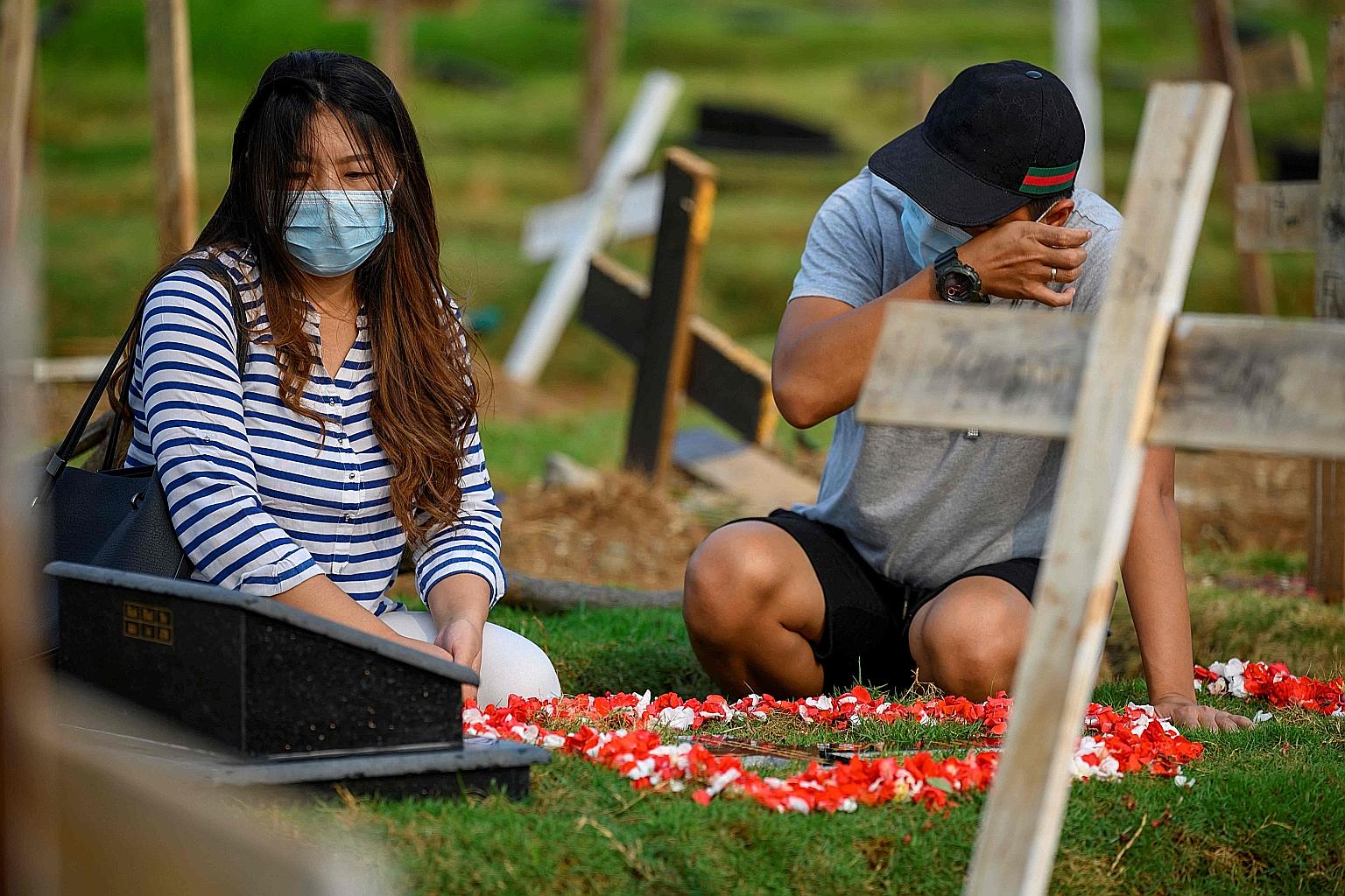 Ms Tirsa Manitik and Mr Erik Alexander mourning at the grave of their baby, who died of Covid-19, at the Tegal Alur cemetery in Jakarta.
