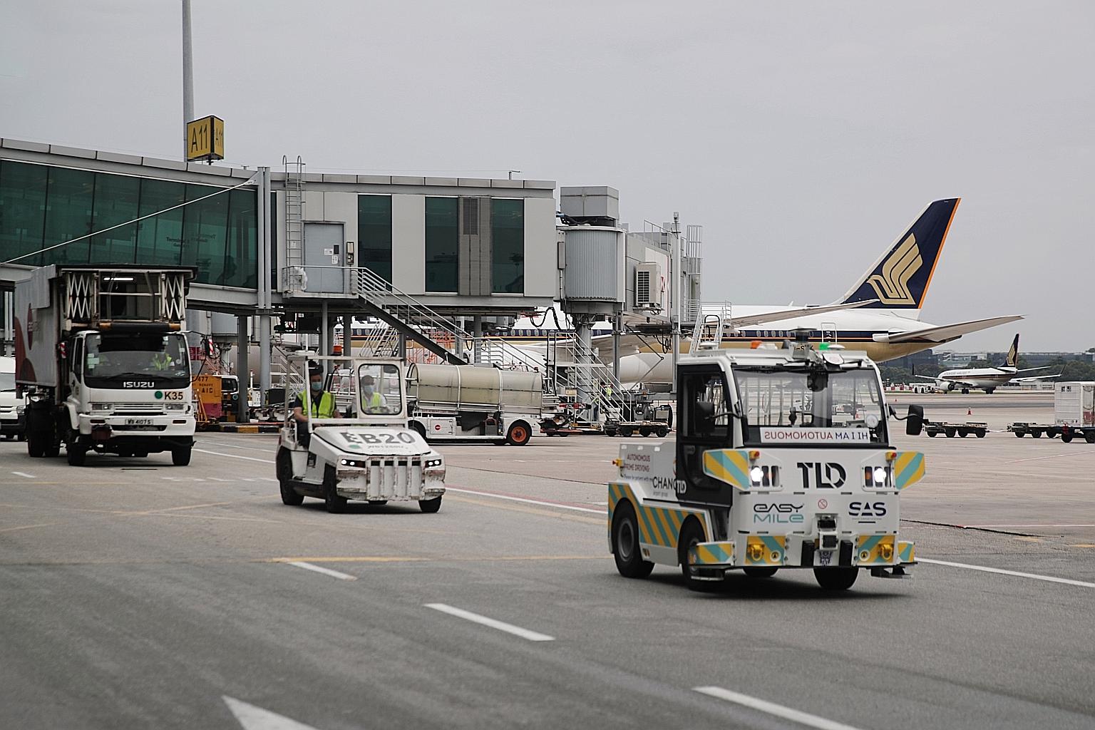 The autonomous tractor (right), developed by airport ground support equipment manufacturer TLD and autonomous vehicle firm EasyMile, during a preview at Changi Airport yesterday. Changi Airport Group (CAG) said it will be working with ground handler