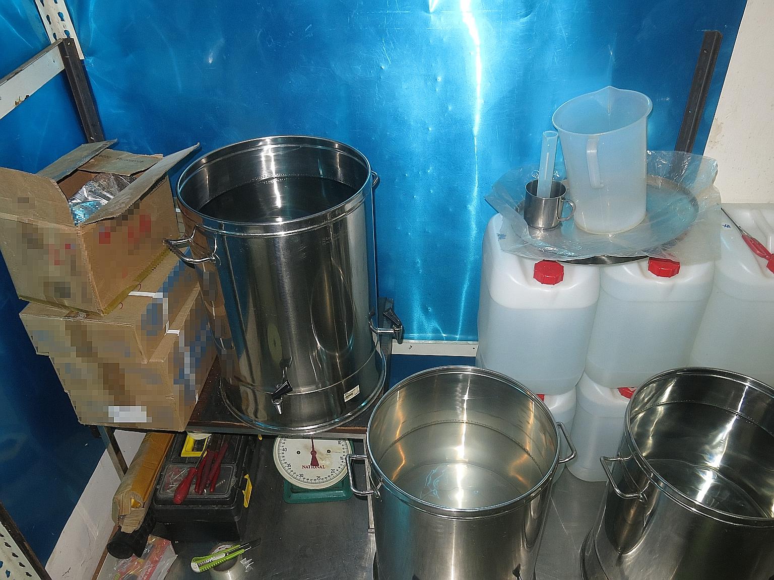 In total, a Singapore-registered car, 673 bottles, 34 jerry cans and two pails of illegally produced liquor, along with apparatus suspected to be used to produce the liquor - some of which are pictured above - were seized during an operation by Singa