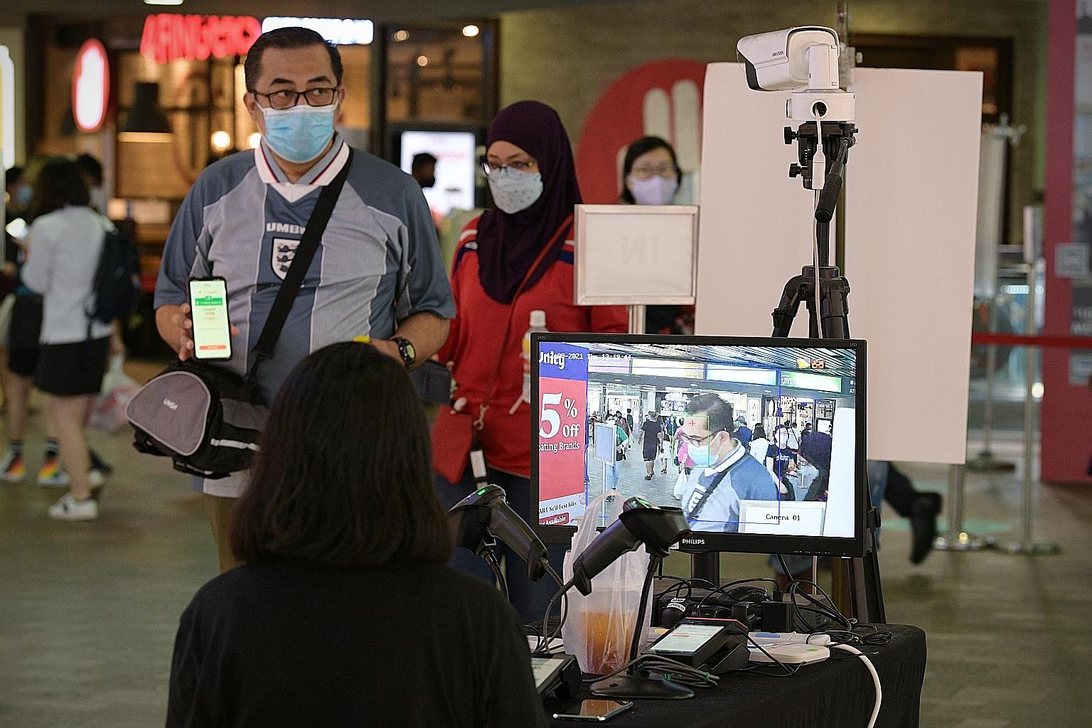 A temperature screener stationed at Causeway Point mall in Woodlands last Thursday. Demand for screeners has been falling as more people get vaccinated, say employment agencies.
