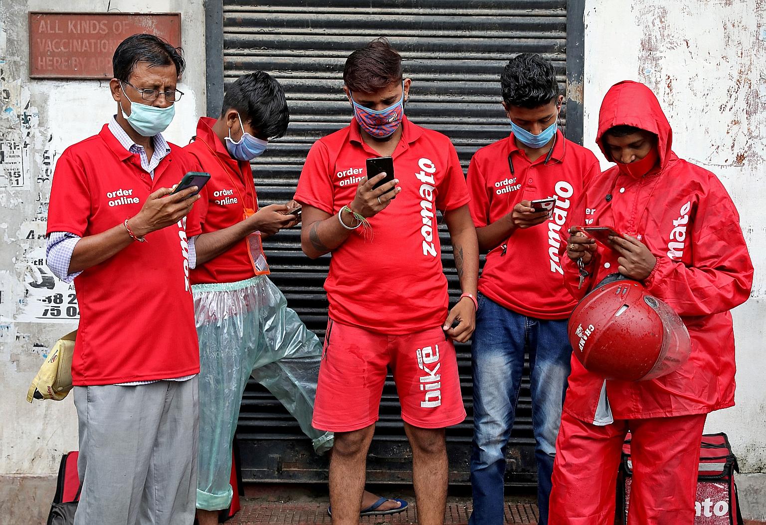 Delivery workers from Indian food delivery service Zomato waiting to collect orders outside a restaurant in Kolkata last month. Some of the company's riders have complained of long working hours that come with risks such as accidents, police harassme