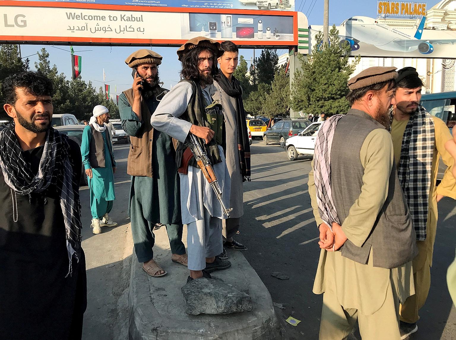 An armed Taleban militant standing guard outside Hamid Karzai International Airport in Kabul yesterday. Images of people clinging to a departing American military plane as it took to the skies went viral.