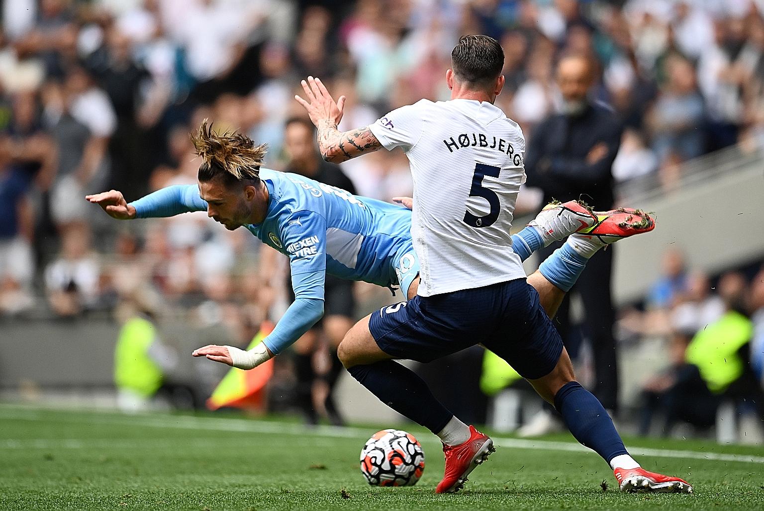Manchester City's new player Jack Grealish is brought down by Tottenham's Pierre-Emile Hojbjerg in their English Premier League match.