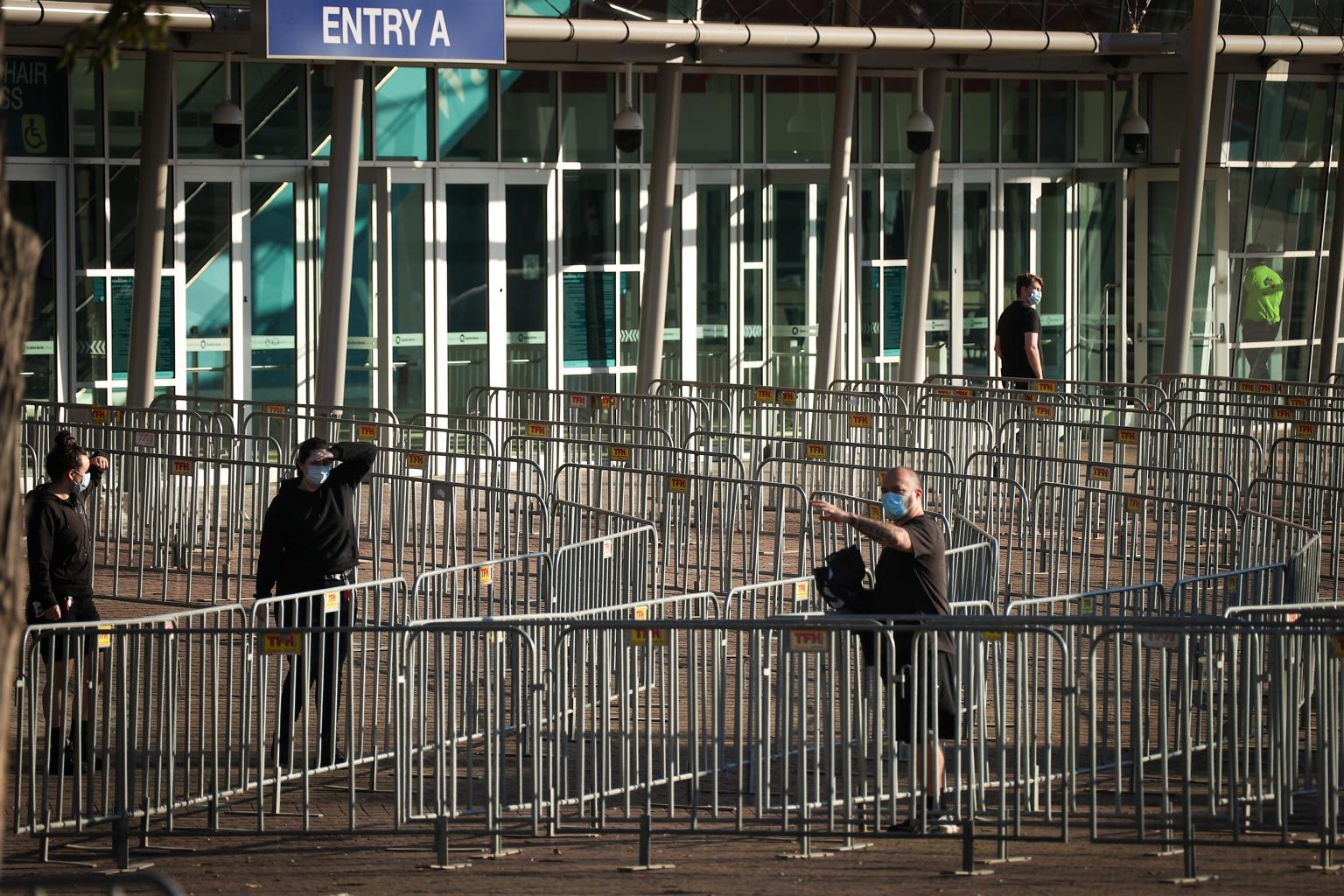 Workers putting up fencing outside Qudos Arena near the Sydney Olympic Park Vaccination Centre on Sunday, as virus cases surge in the Australian city.
