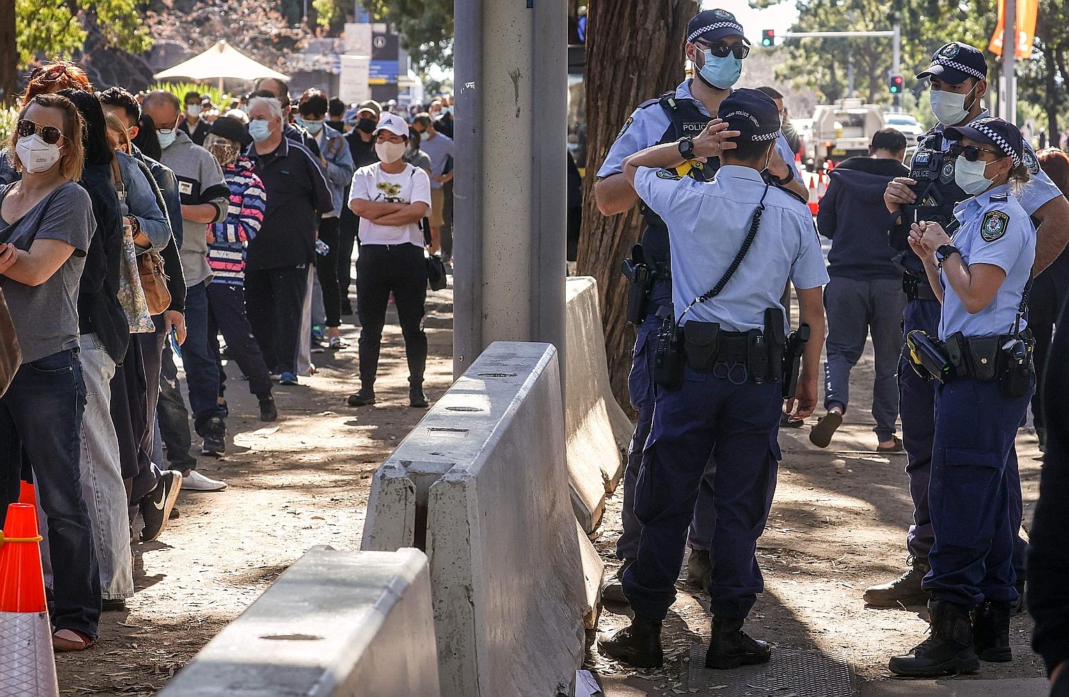 New South Wales police on duty as people waited in line for their Covid-19 shots at the Sydney Olympic Park Vaccination Centre on Monday.