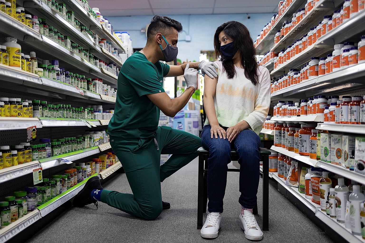 A woman getting a dose of the Pfizer-BioNTech Covid-19 vaccine at a pharmacy in Schwenksville, Pennsylvania, last Saturday. Under a plan expected to be announced yesterday, some five million people in the United States - everyone who got two doses of