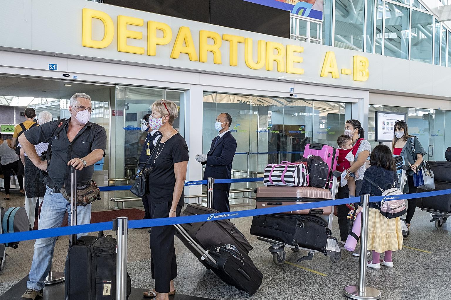 Australian citizens queueing as they waited for a repatriation flight at Ngurah Rai International Airport in Bali yesterday. Clinics in areas where many expatriates live, such as Bali, will be appointed to help provide verification services for those