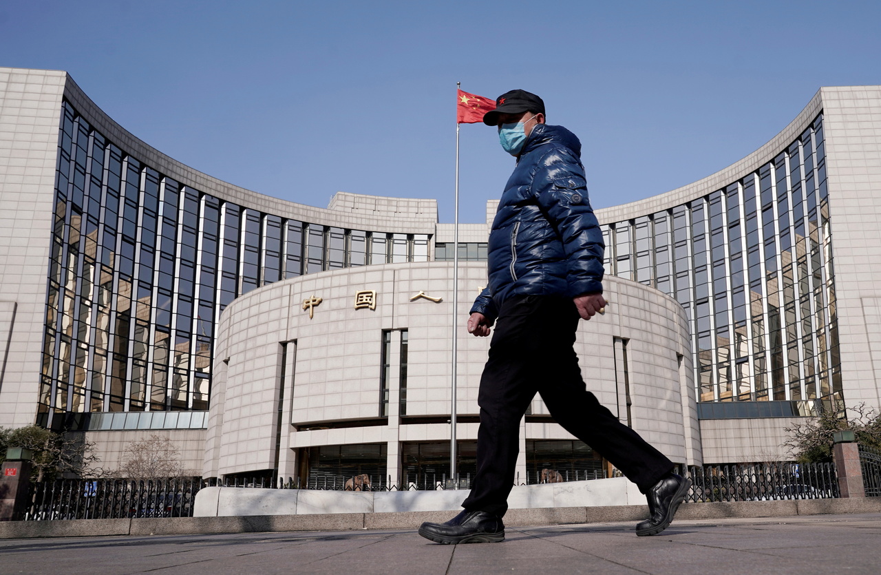 <p>FILE PHOTO: A man wearing a mask walks past the headquarters of the People's Bank of China, the central bank, in Beijing, China, February 3, 2020. REUTERS/Jason Lee/File Photo</p>