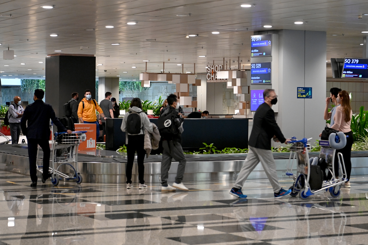 <p>Passengers wearing face masks collecting luggages at Changi Airport Terminal 3 on November 5, 2021. The expanded Vaccinated Travel Lane (VTL) scheme in Singapore has given the meetings, incentives, conventions and exhibitions (Mice) sector a boost, wi