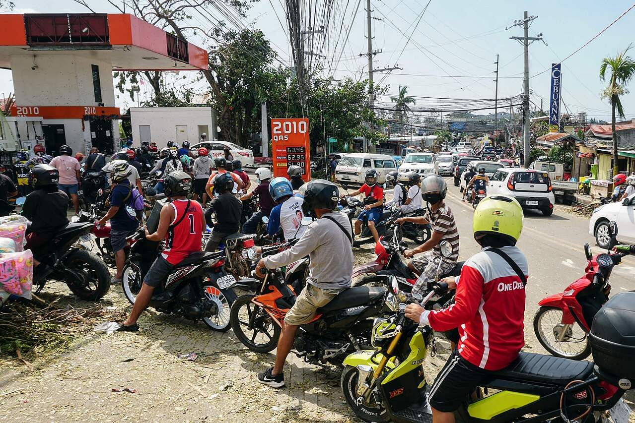<p>Motorists queue up for gas up at a fuel station in Cebu City on December 18, 2021, days after Super Typhoon Rai hit the area. (Photo by Cheryl BALDICANTOS / AFP)</p>