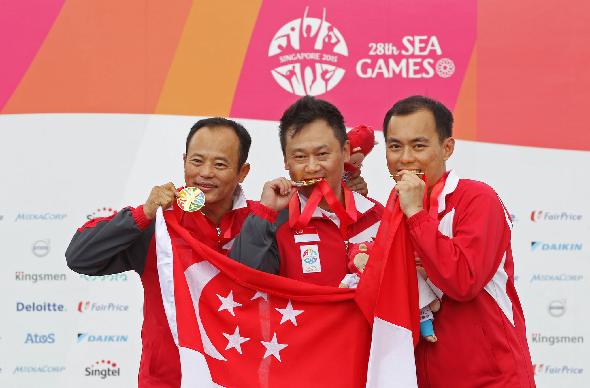 28th SEA Games Singapore 2015 - National Shooting Centre, Singapore - 11/6/15. Shooting - Men's 50m Pistol Team - Final - Singapore's Gai Bin, Lim Swee Hon and Poh Lip Meng celebrate with their gold medals on the podium. SEAGAMES28 TEAMSINGAPORE. Mandator
