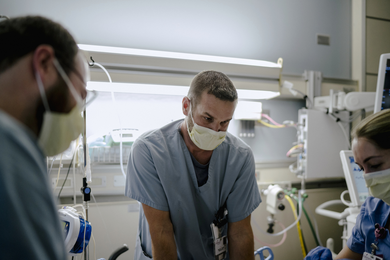 Respiratory therapist Eric Schlicht and colleagues with a patient in a Covid-19 ICU at Covenant HealthCare in Saginaw, Michigan, on Dec 15, 2021.