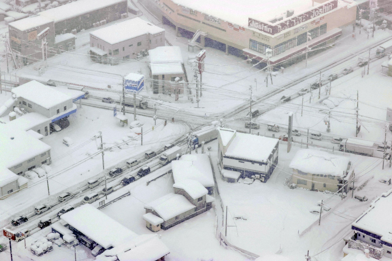 Vehicles stranded in the snow in Hikone, Shiga prefecture, on Dec 27, 2021.