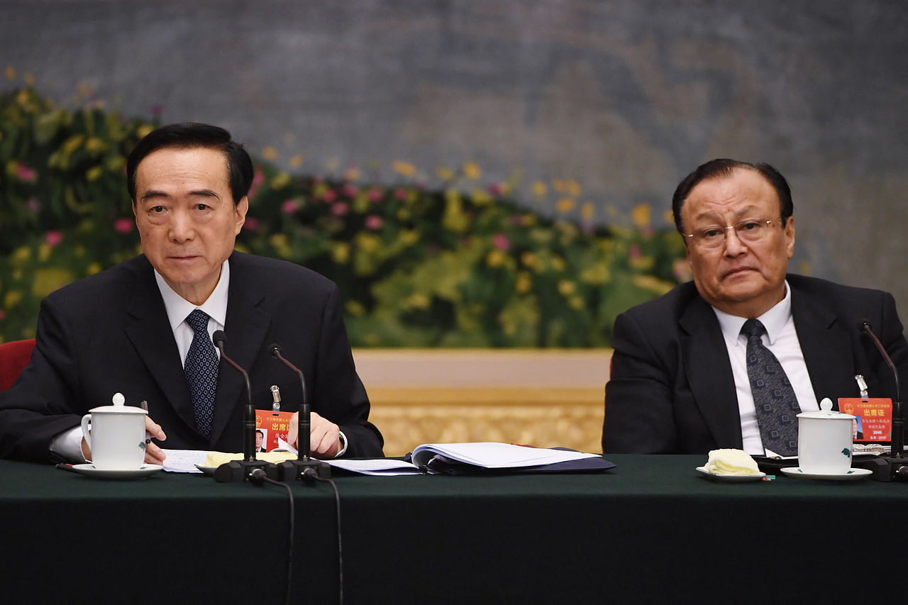 <p>Xinjiang Party Secretary Chen Quanguo (L) and chairman of Xinjiang's government Shohrat Zakir (R) listen to a question during the Xinjiang delegation meeting at the ongoing National People's Congress at the Great Hall of the People in Beijing on March 