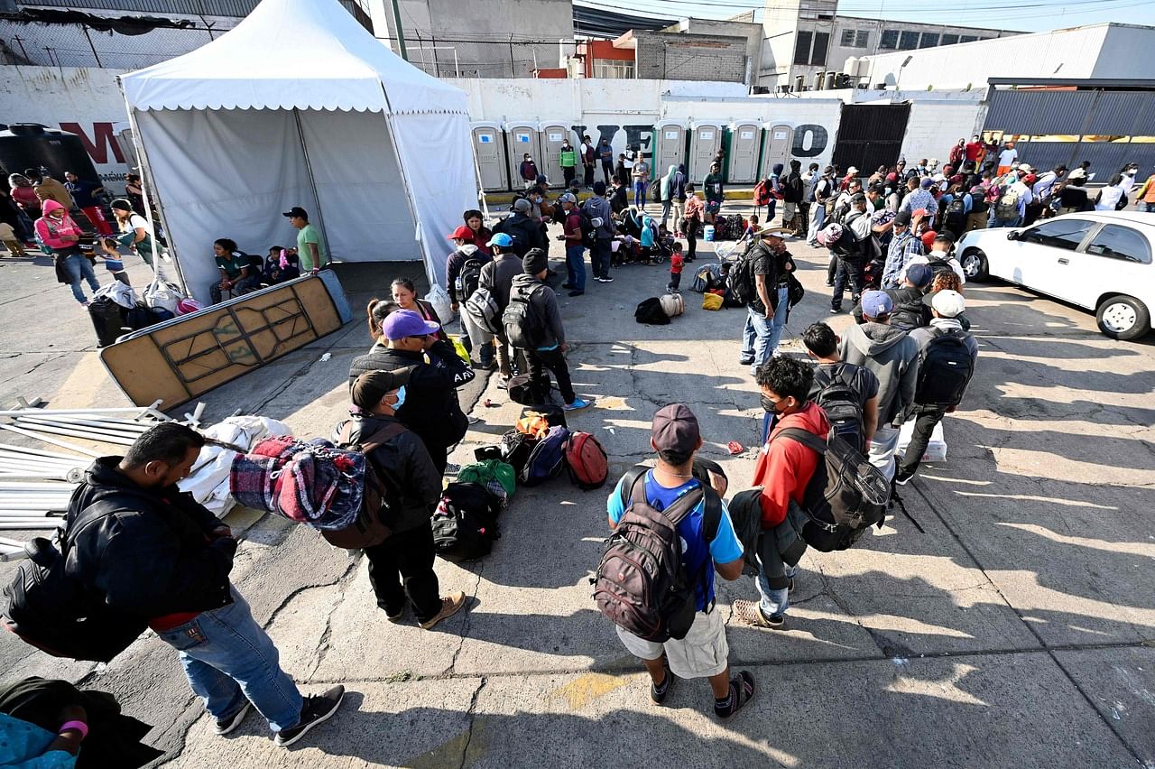 <p>Migrants heading in a caravan towards the US wait for buses at the "House of the Pilgrim San Juan Diego" in Mexico City, on December 22, 2021. - Central American migrants will be transported to the cities of Monterrey, Juarez and Hermosillo. There, wit