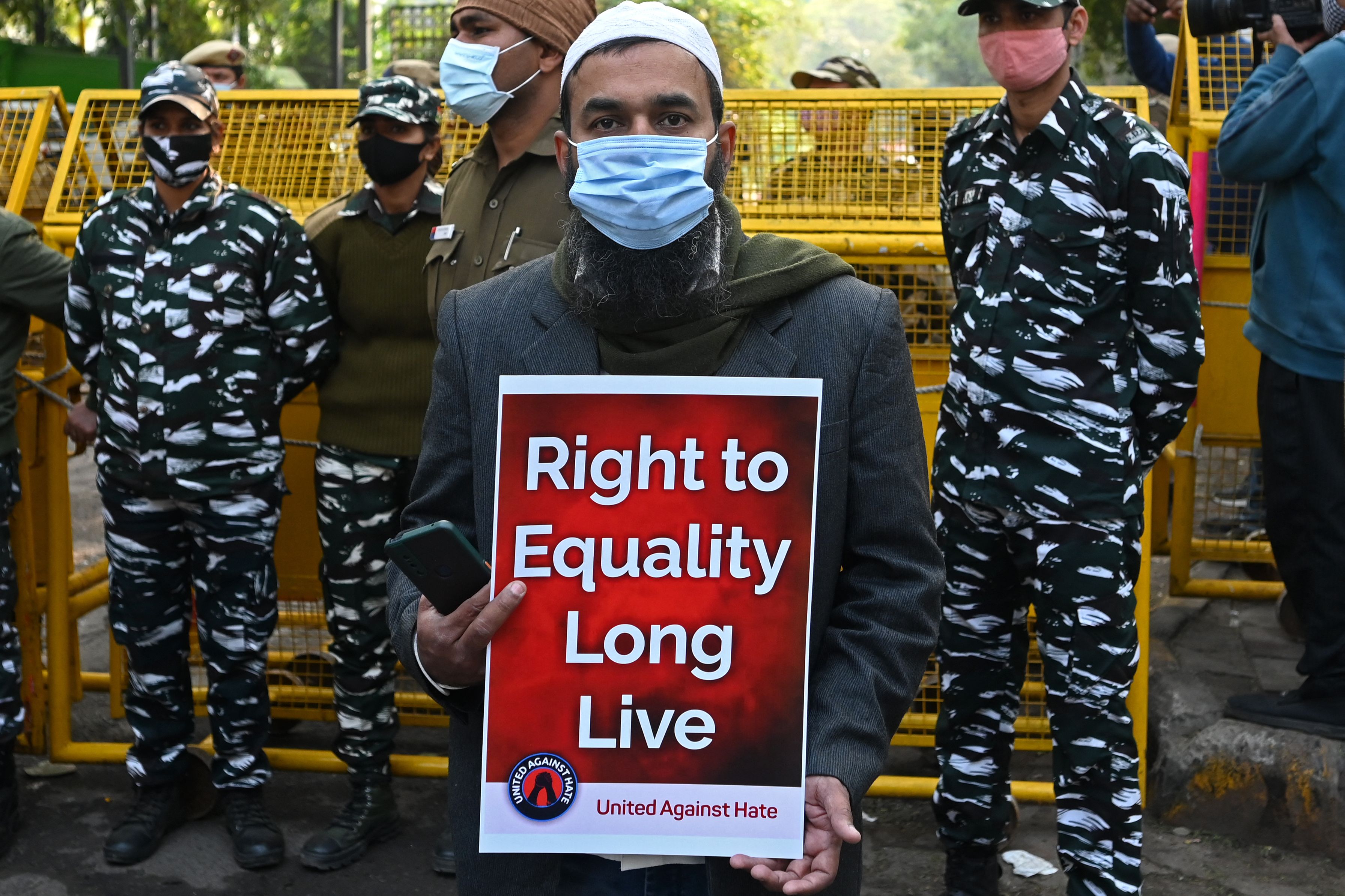 A protester holds a placard during a demonstration against hate speech in New Delhi on Dec 27, 2021.