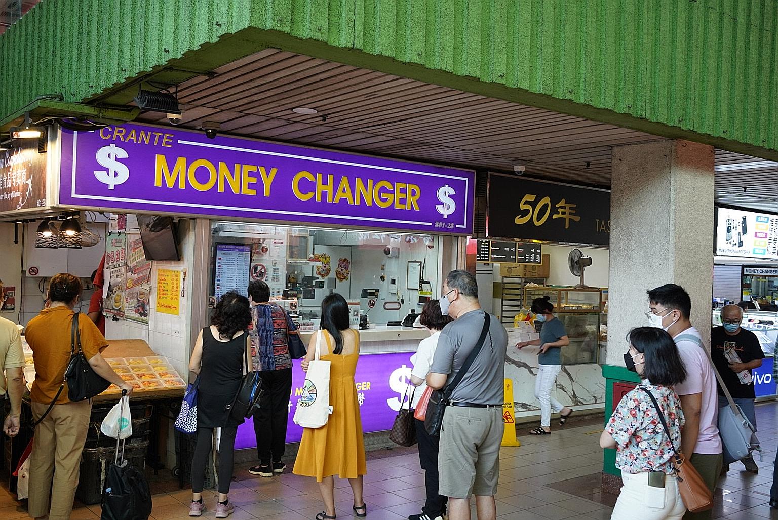 People queueing at a money changer outlet in People's Park Complex yesterday. Most money changers said they were upbeat about sales of the Malaysian ringgit. ST PHOTO: KOLETTE LIM
