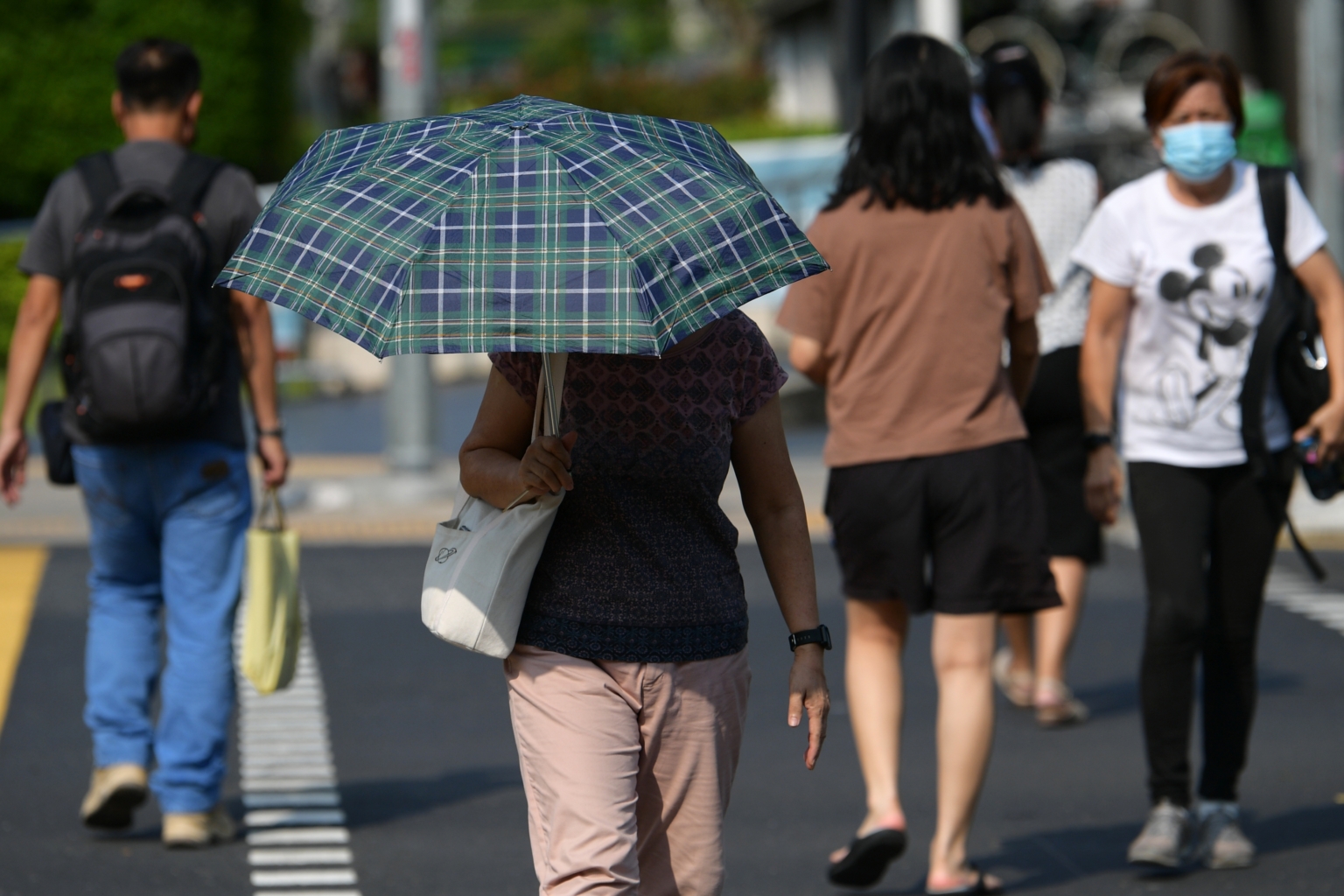 Woman holding an umbrella against the sun in Singapore