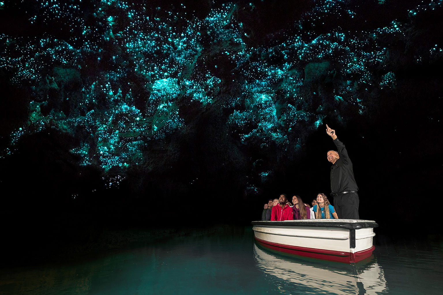 people taking a boat ride in the dark through waitomo caves to see glowworms in hamilton waikato