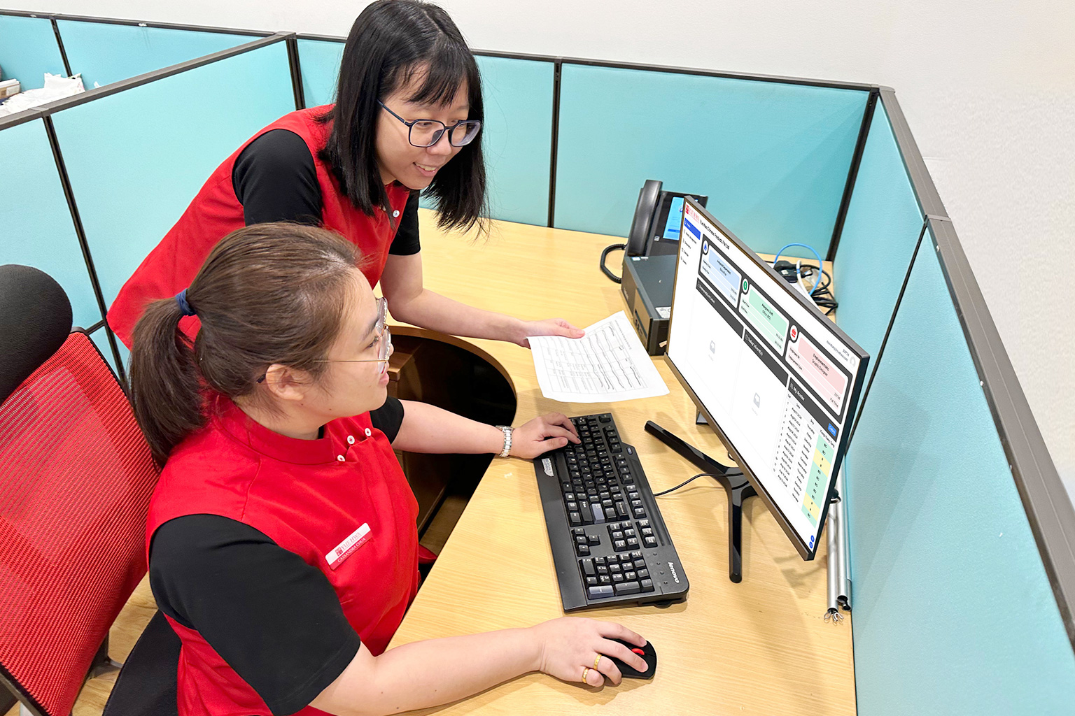 Two Yue Hwa Female Staff Discussing the Staff Rostering In Front of a Computer