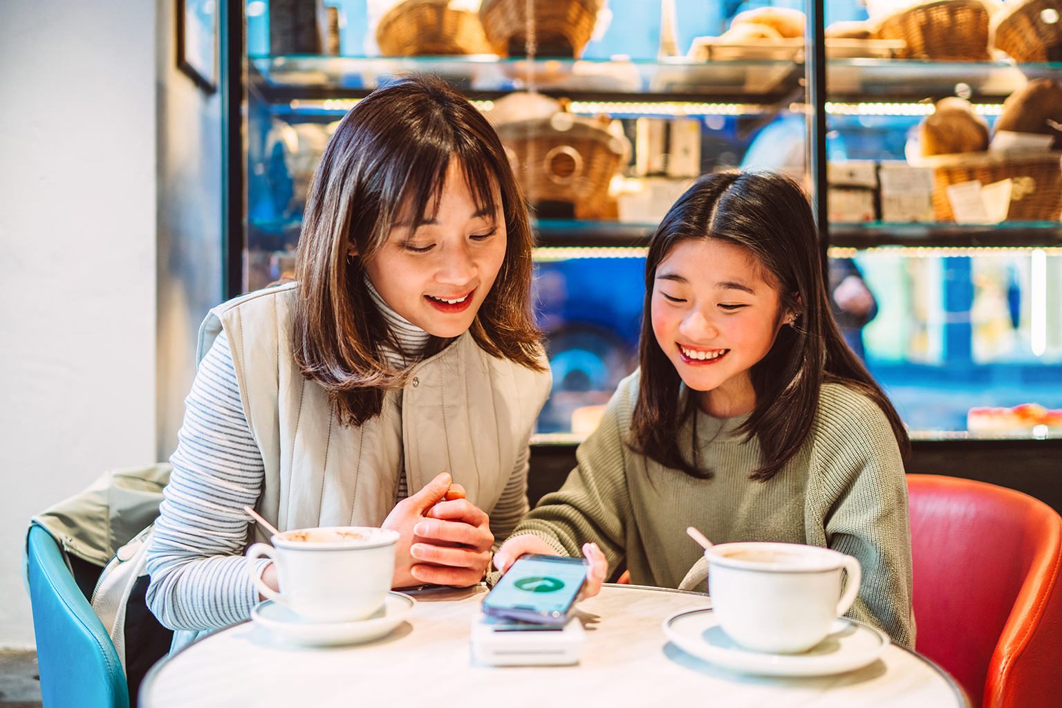 Asian Chinese mother and tween daughter trying out digital payments