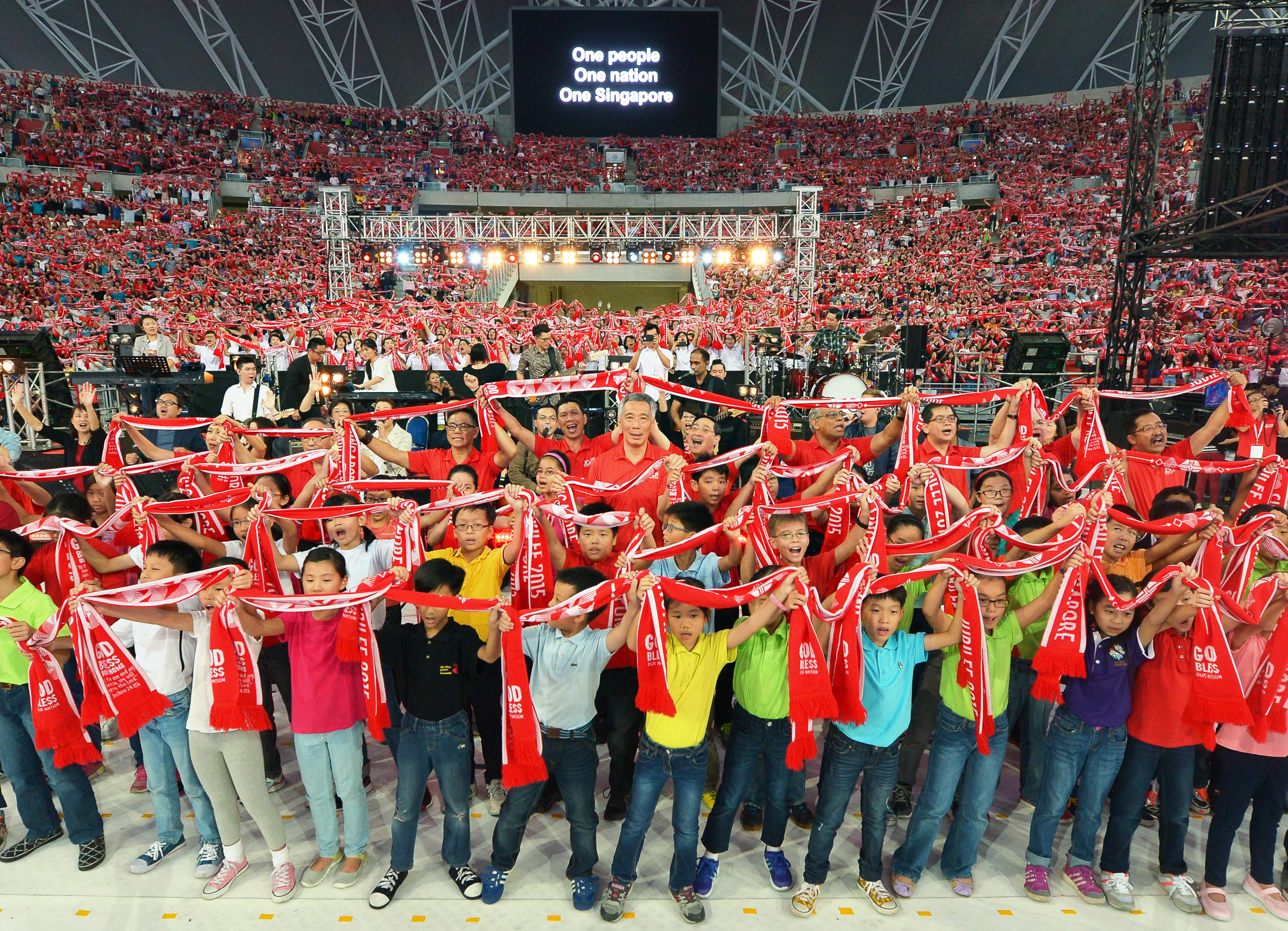 PM Lee Hsien Loong joining children on stage to sing One People, One Nation, One Singapore with the crowd during the Jubilee Day of Prayer at the Sports Hub yesterday. The event was co-organised by the National Council of Churches in Singapore and th