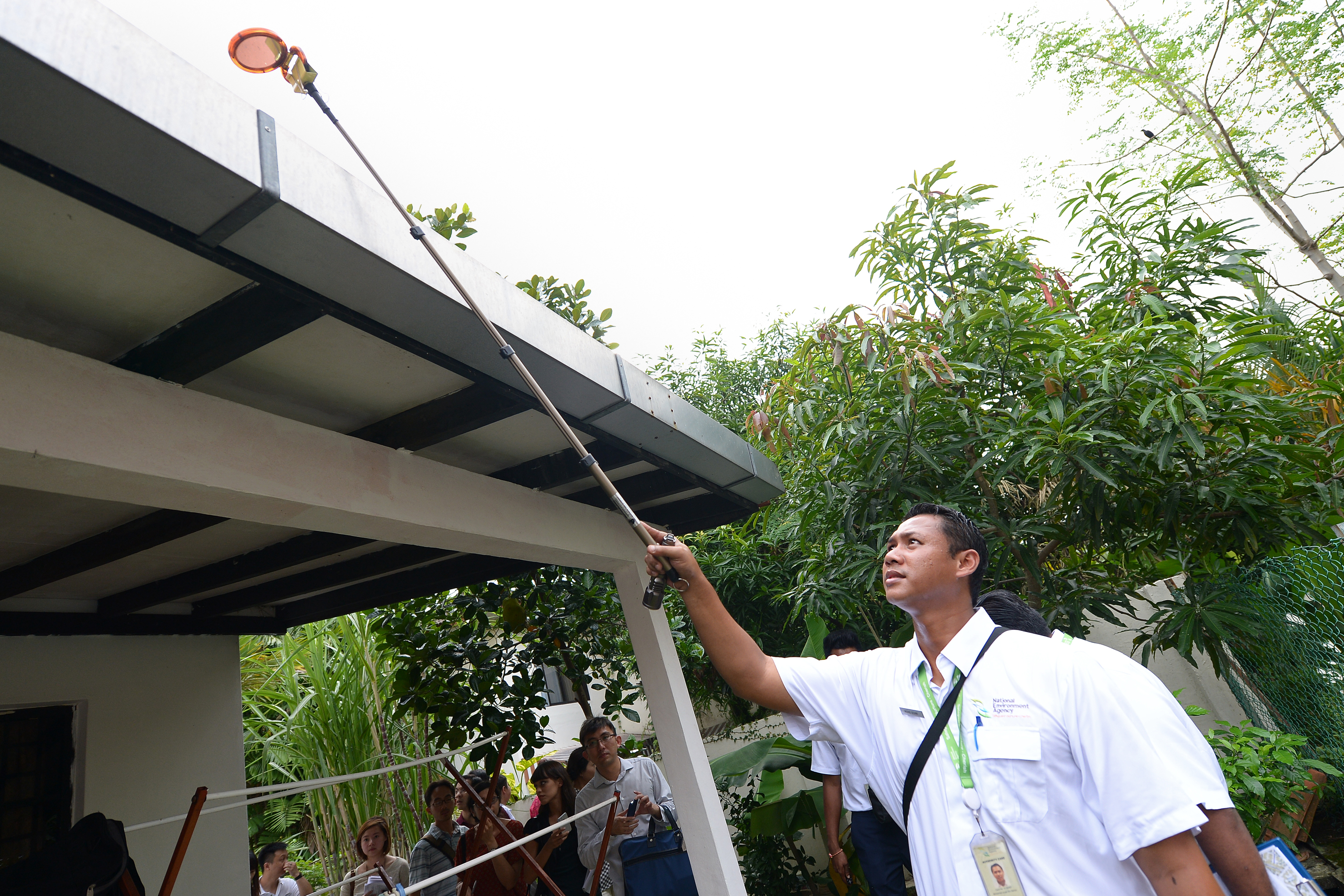 An NEA officer checking the roof of a house for mosquito-breeding sites. Vector control remains a key strategy in the fight against dengue.