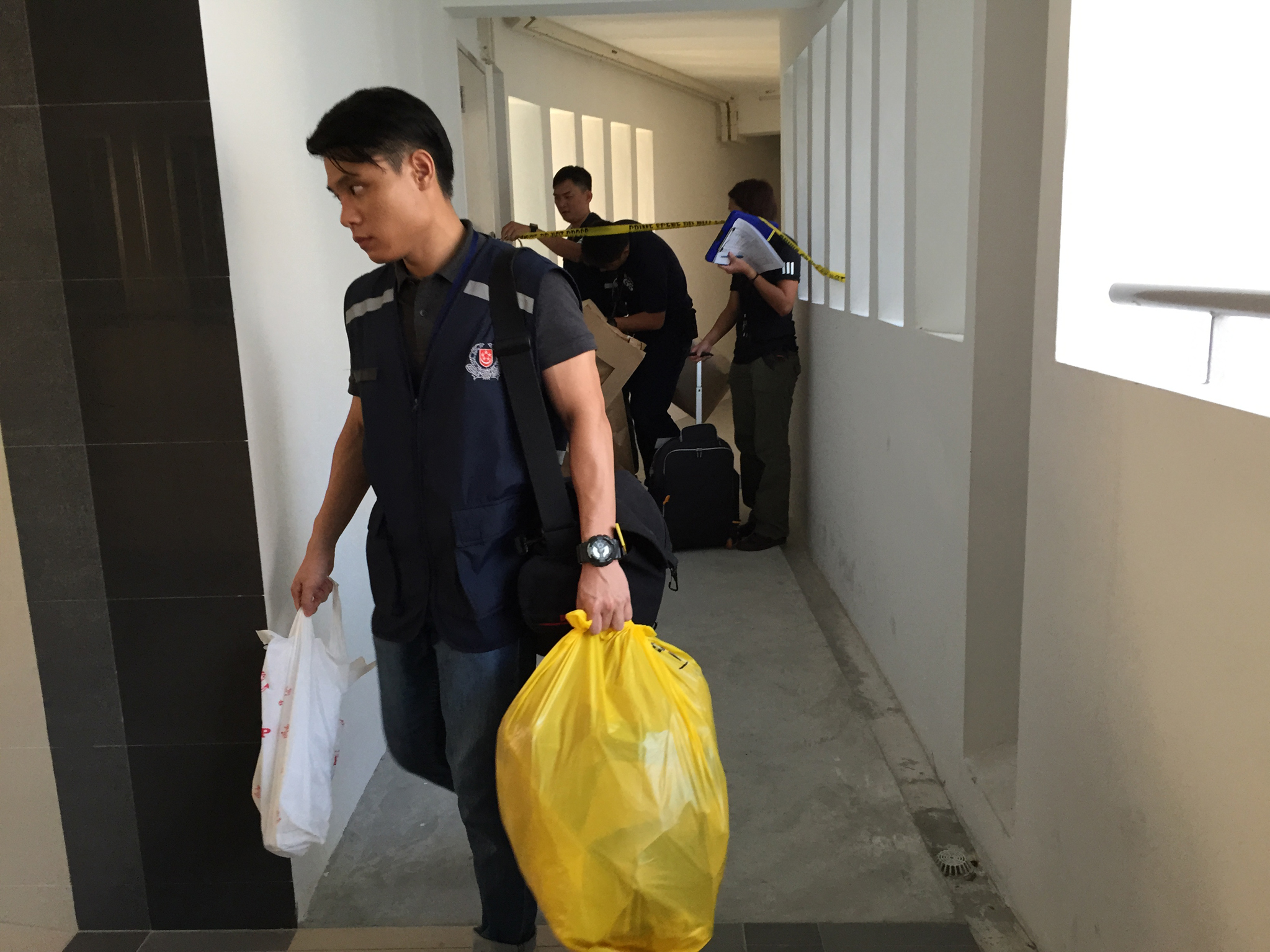Police officers leaving the couple's Senja Road flat yesterday morning. The couple have been married for close to two years and have a 14-month-old daughter. Police have classified the case as murder.