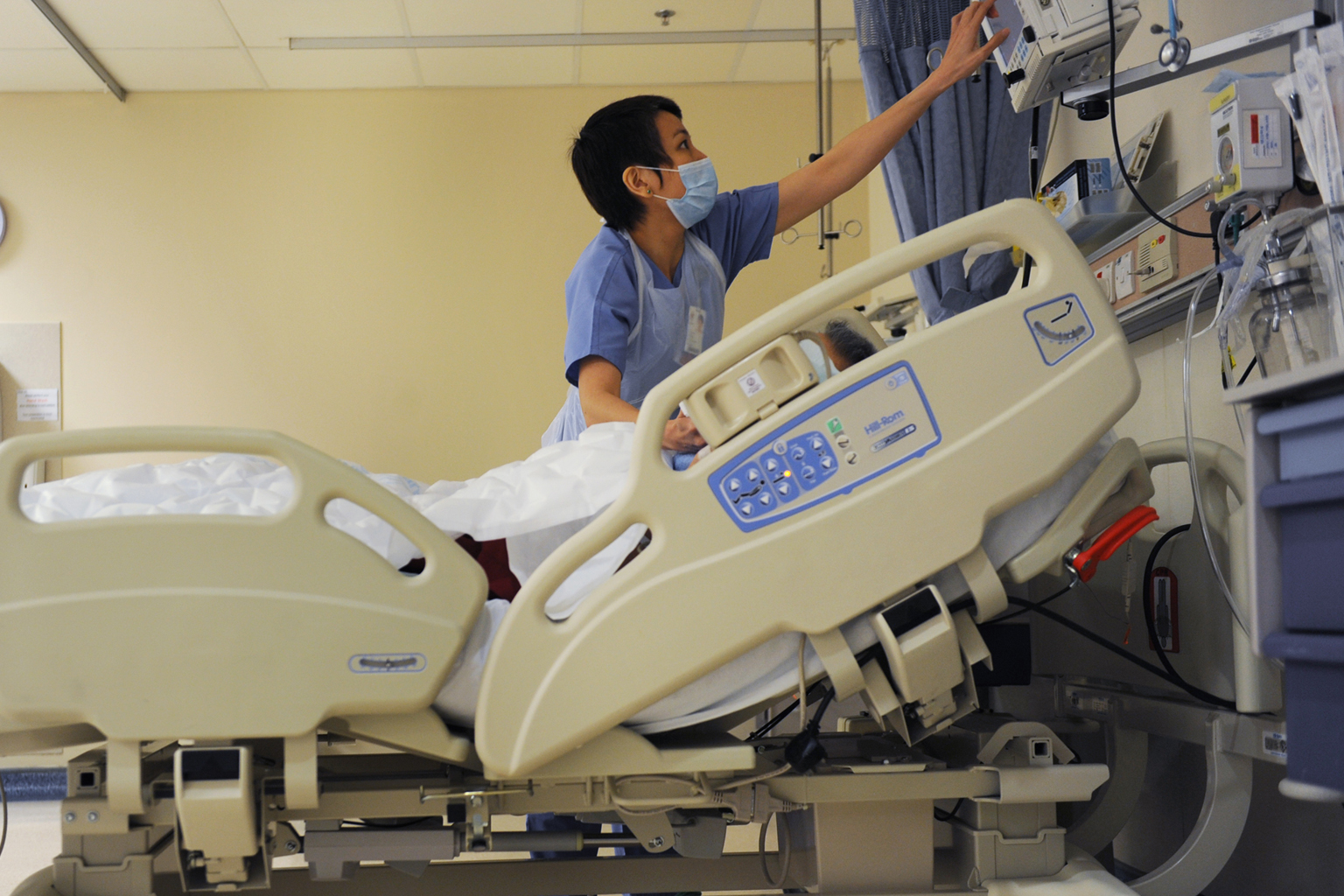 A nurse at a hospital's post-anaesthesia care unit checking the monitor which displays the vital signs of a patient who has just emerged from surgery. Under a general anaesthetic, a person should have no recall of intra-operative events.
