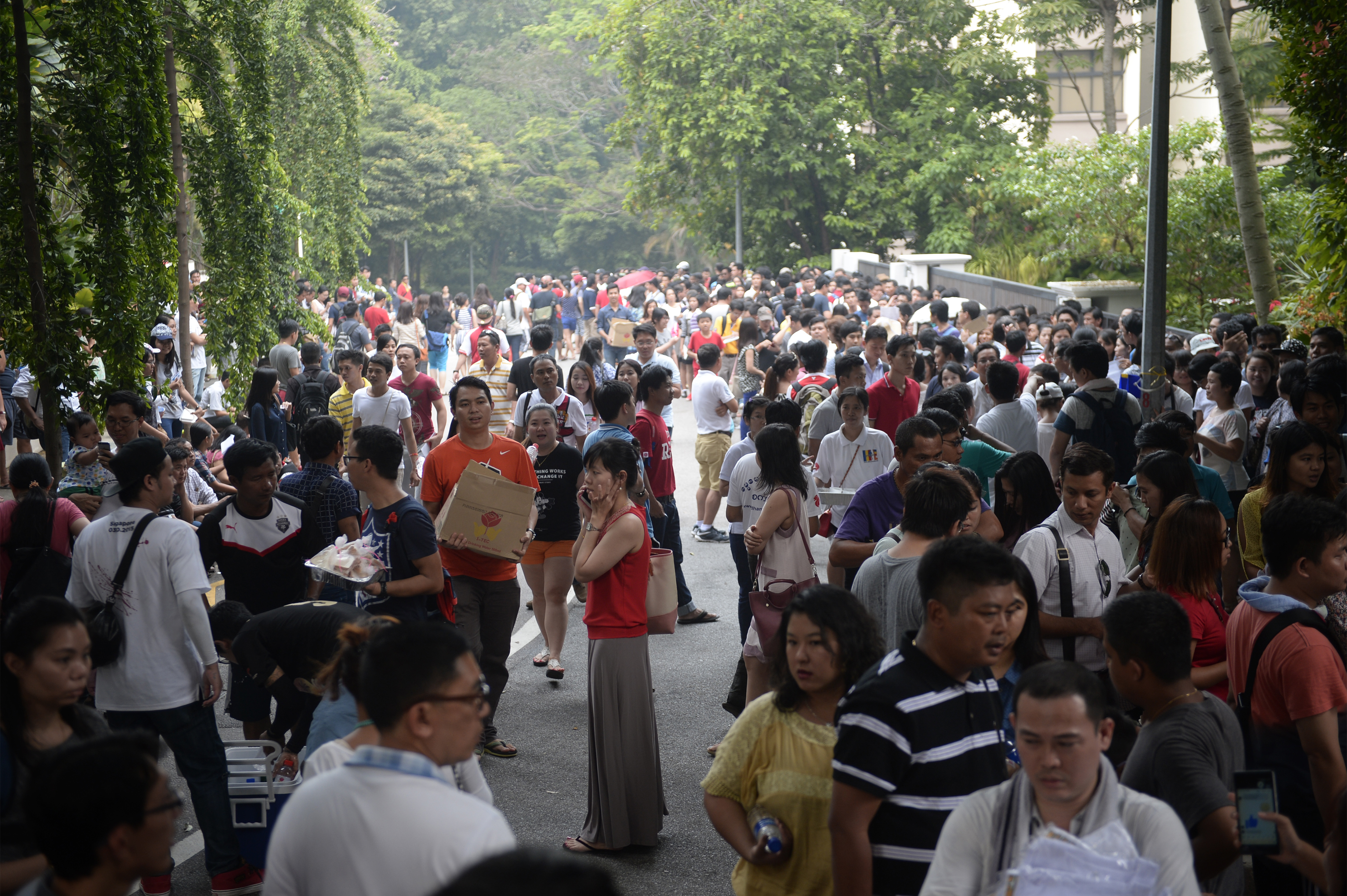 The queue outside the Myanmar Embassy yesterday, with some people giving out free food and drinks to those waiting in line. Unlike the scenes of confusion on Saturday, yesterday's crowd arrived prepared for the long wait.