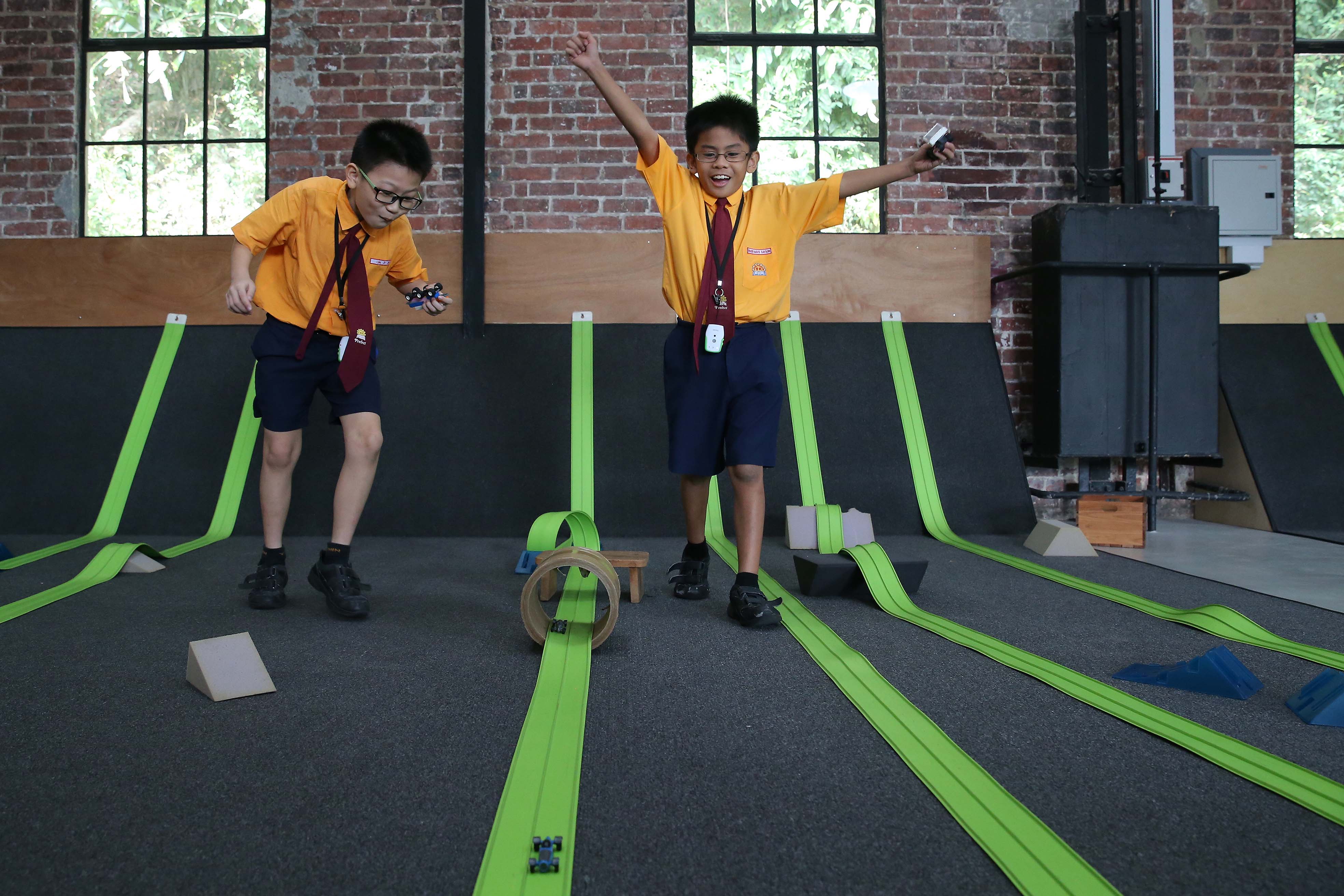 Yumin Primary School pupils Jack Lim (left) and Brasen Mavis Sayson, both nine, having fun racing toy cars at Playeum.