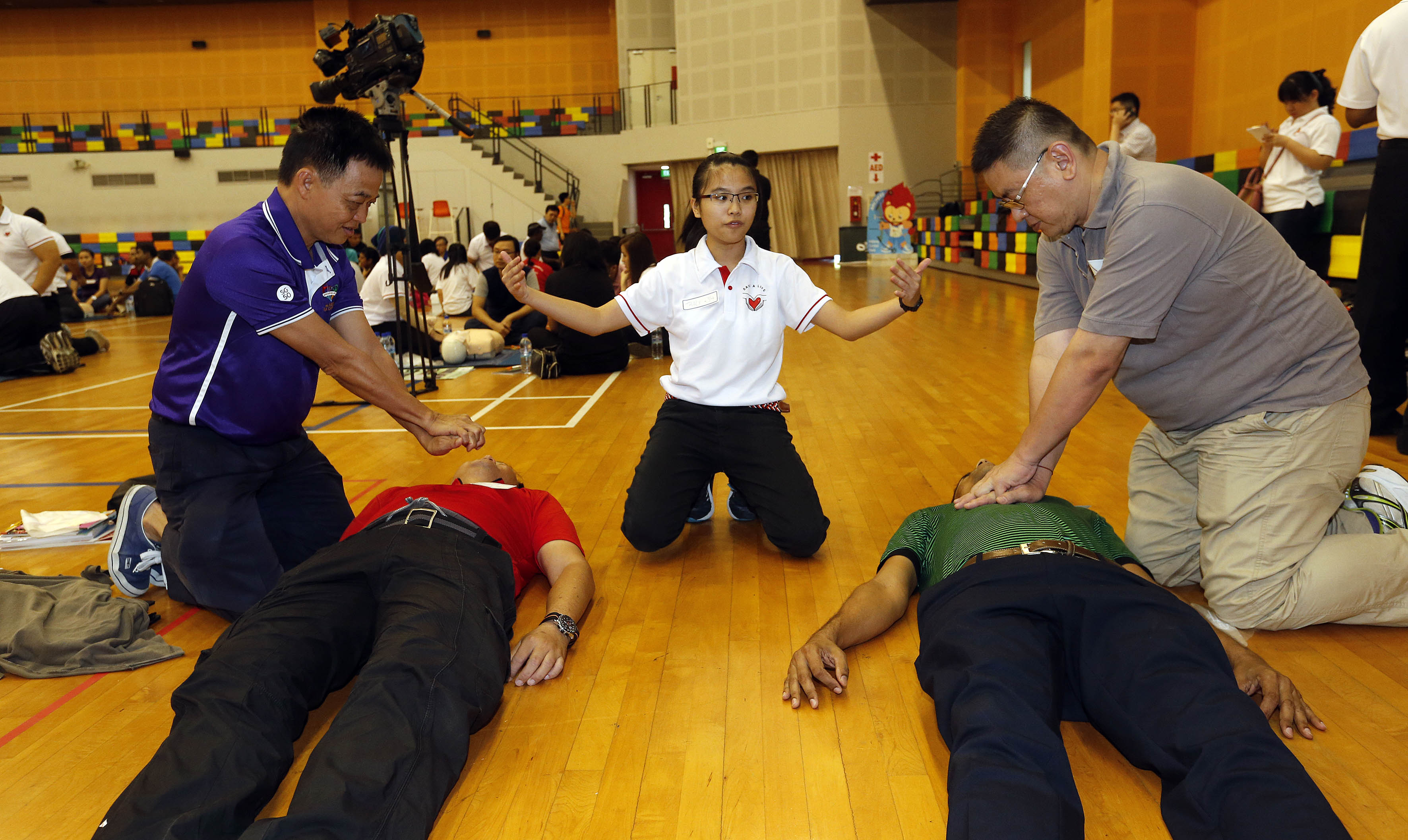 MsTracy Koh (centre), 20, teaching Pasir Ris-Punggol GRC residents how to perform cardiopulmonary resuscitation at the launch of the Citizen First Responder course yesterday. Those who complete it will be certified as first aiders for two years.