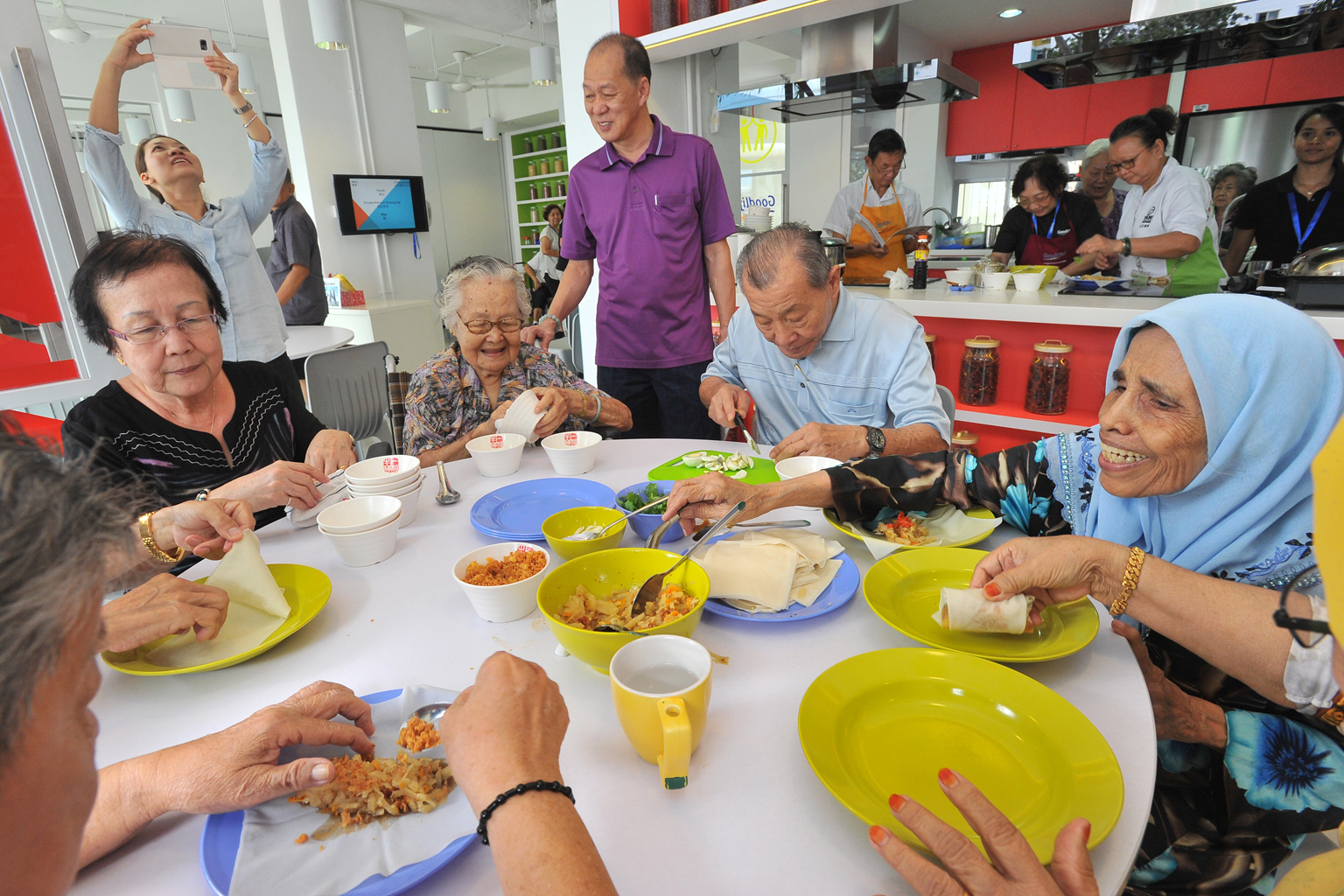 The elderly residents - (from left) Madam Sng Kah Huay, 68; Madam Ing; Mr Looi Hong Teck (standing), 63; Mr Ku and Madam Hindon - preparing popiah at the GoodLife! Makan kitchen on Wednesday.