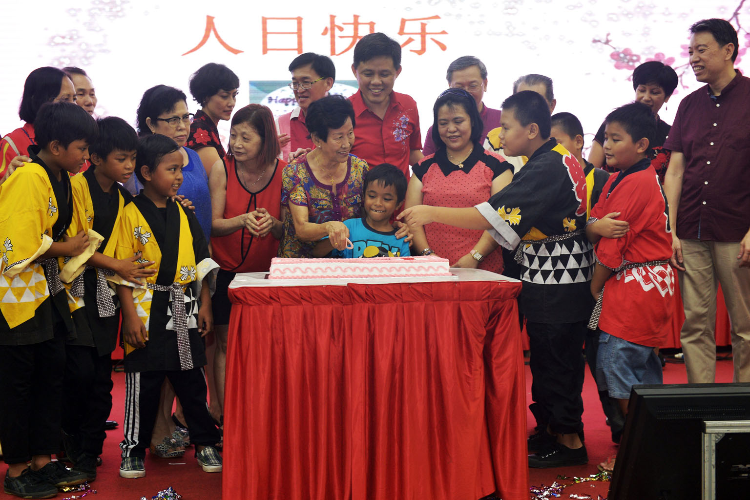 Mr Chan (centre), fellow Tanjong Pagar GRC MPs, and Radin Mas SMC MP Sam Tan (on Mr Chan's left), celebrating with residents whose birthdays fall this month. Madam Mak Kim Ho 77, and Anif Suzaini, eight, cut a cake to celebrate "ren ri", or "everyone
