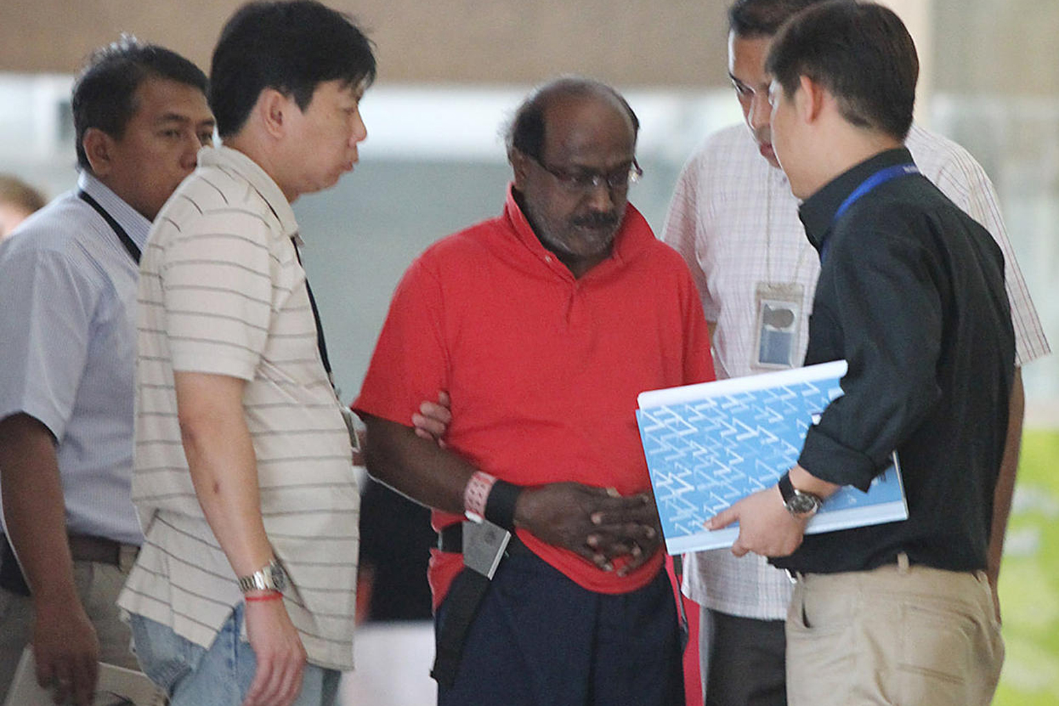 Govindasamy (centre), seen in a 2011 file photo, now faces a maximum of 10 years' jail and a fine. He had hit his lawyer's wife on the head with a bicycle chain and set fire to the law office with the woman still inside, but the judicial commissioner