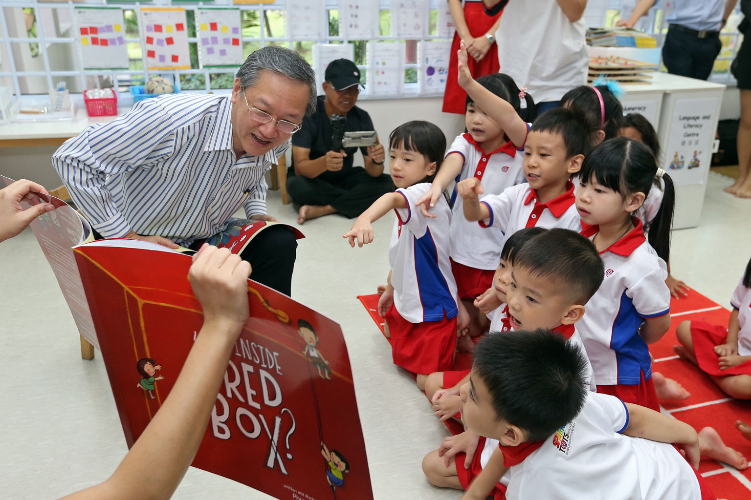 Mr Tan telling children in a K2 class, at the PAP Community Foundation (PCF) Sparkletots Preschool in Radin Mas yesterday, stories from What's Inside The Red Box. The book comes with pages for young readers to fill in their own hopes and dreams.