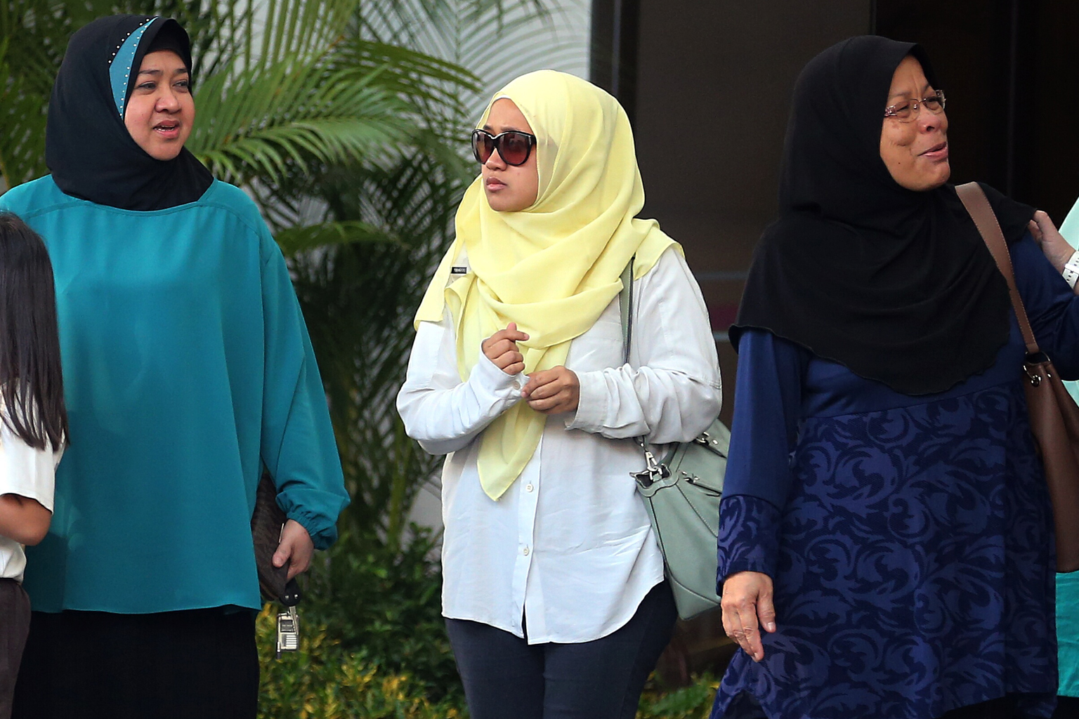 Ms Nurul Asyikin (centre) with family members outside the coroner's court yesterday. Her husband had second-degree burns on more than 80 per cent of his body.