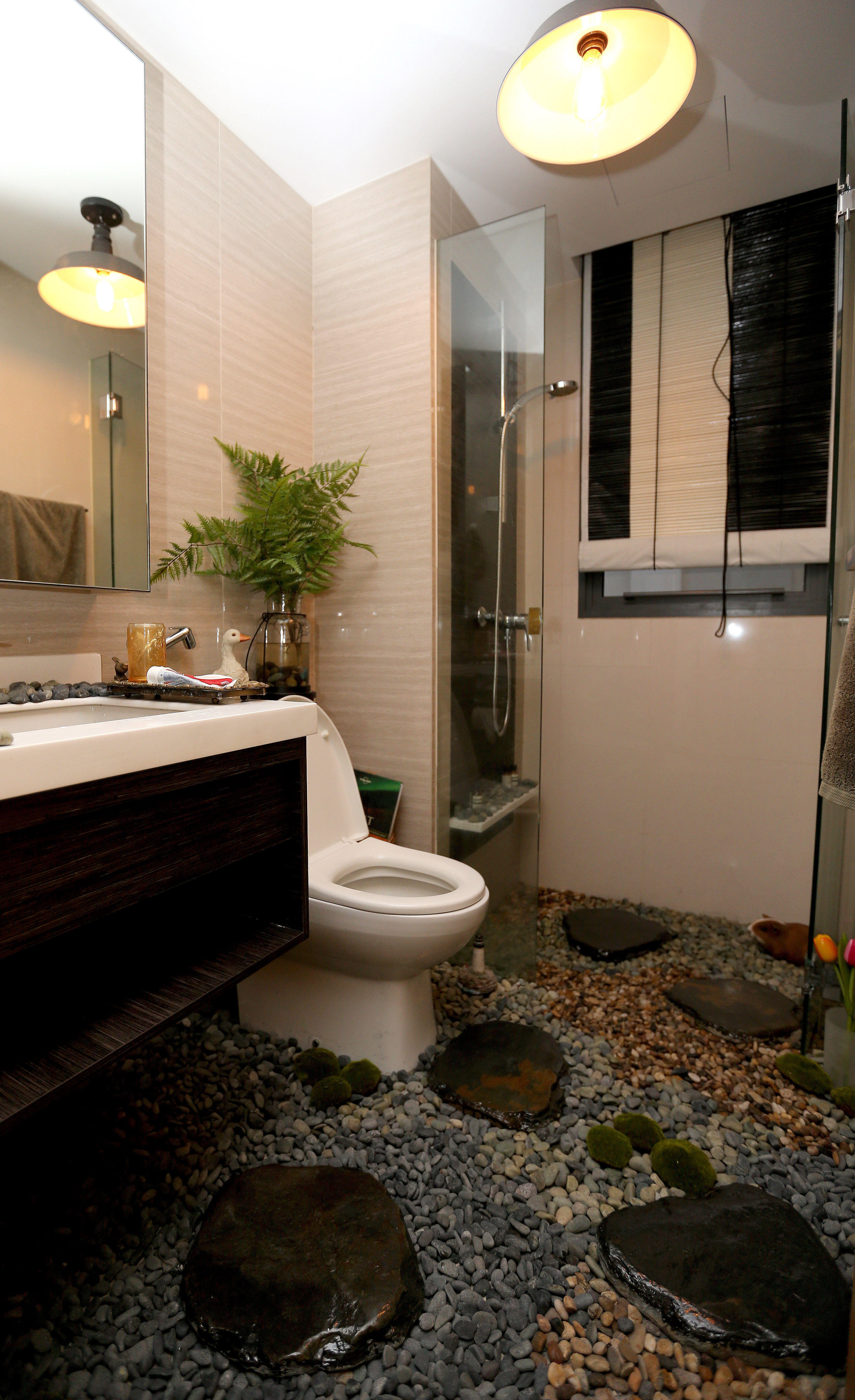 Loose gravel and stepping stones add to the tropical colonial interior design of the guest bathroom (above).  