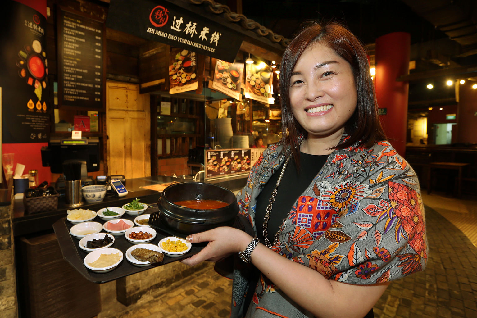 Ms Crystal Chou, owner of Shi Miao Dao Yunnan Rice Noodles in Singapore, with the Tomato noodle set, which comes with 11 side items.