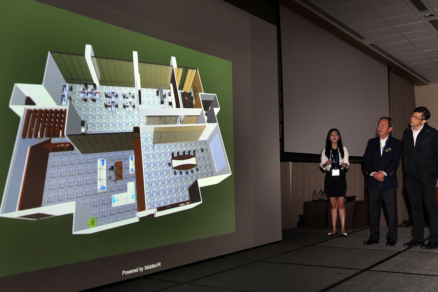 WAF director of strategic partnerships Celine Sim, Mr Chan (centre) and Mr Teo looking at a demonstration of a model produced by the 3D-Scan Visualiser, which was launched yesterday.