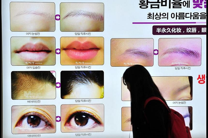 A pedestrian walking past an advertisement for a plastic surgery clinic in Seoul. South Korea has become a hot plastic surgery destination for Singapore residents. But many are reporting botched operations.