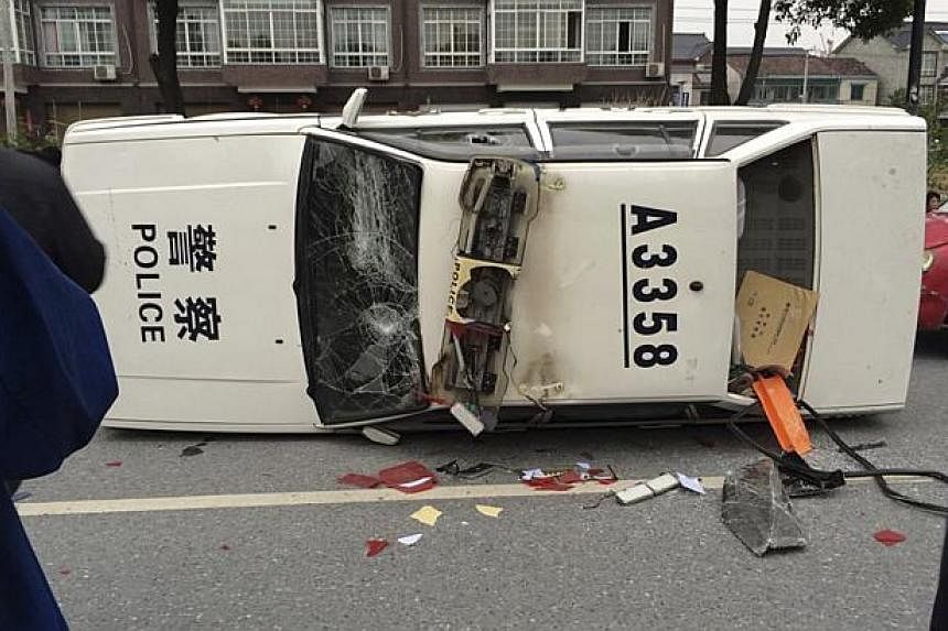 A police car is seen smashed and overturned as demonstrators protest against the construction of a waste incinerator, in the Yuhang district of Hangzhou, Zhejiang province on May 10, 2014. -- PHOTO: REUTERS
