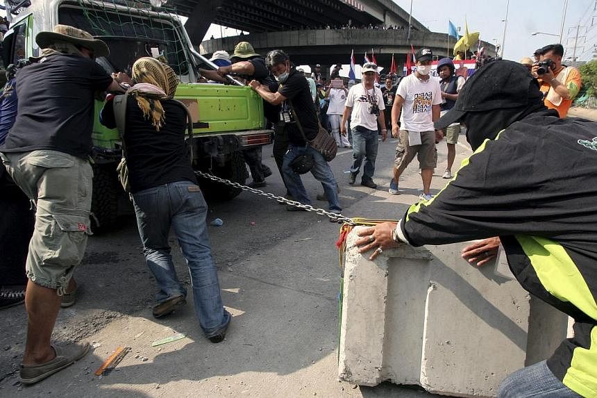 Thai anti-government protesters remove barricade during a rally at the Police Club in Bangkok, Thailand, on May 10, 2014. -- PHOTO: EPA