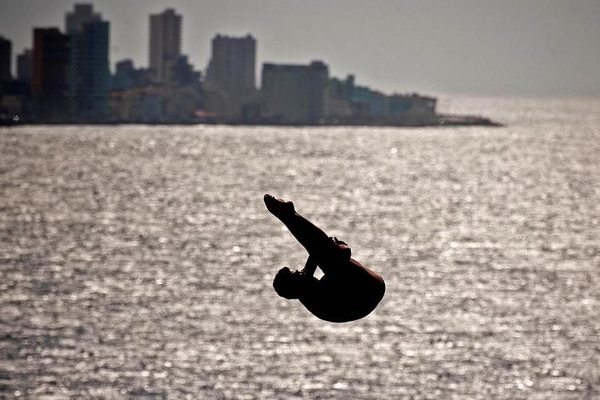 A competitor dives from a 27m high platform during the Red Bull Cliff Diving World Series 2014 at the Morro Castle in Havana, on May 10, 2014. -- PHOTO: AFP