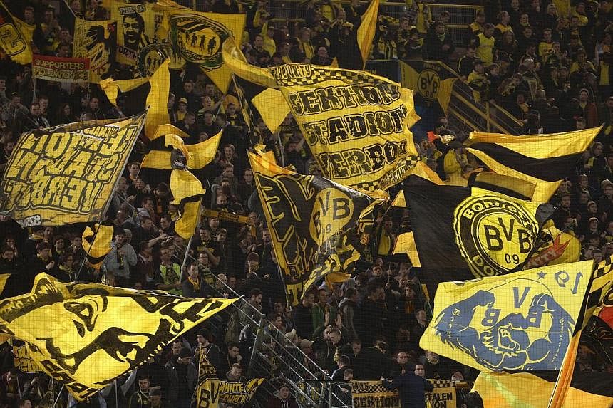 Dortmund's fans cheer prior to the last 16 second-leg UEFA Champions League football match Borussia Dortmund vs Zenit St Petersburg in Dortmund, western Germany on March 19, 2014. Borussia Dortmund were the only European club to average more than 80,