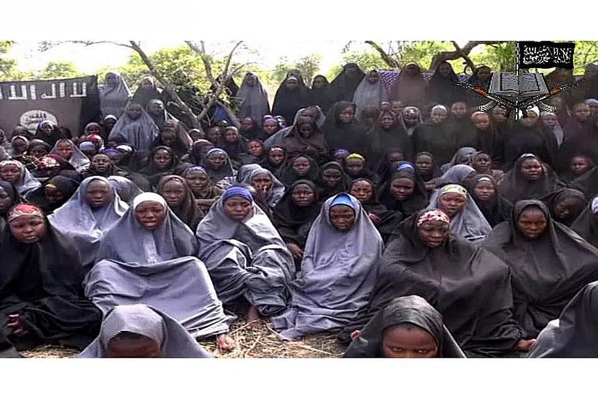 A screengrab taken on May 12, 2014, from a video of Nigerian Islamist extremist group Boko Haram obtained by AFP shows girls, wearing the full-length hijab and praying in an undisclosed rural location. Boko Haram released a new video on claiming to s
