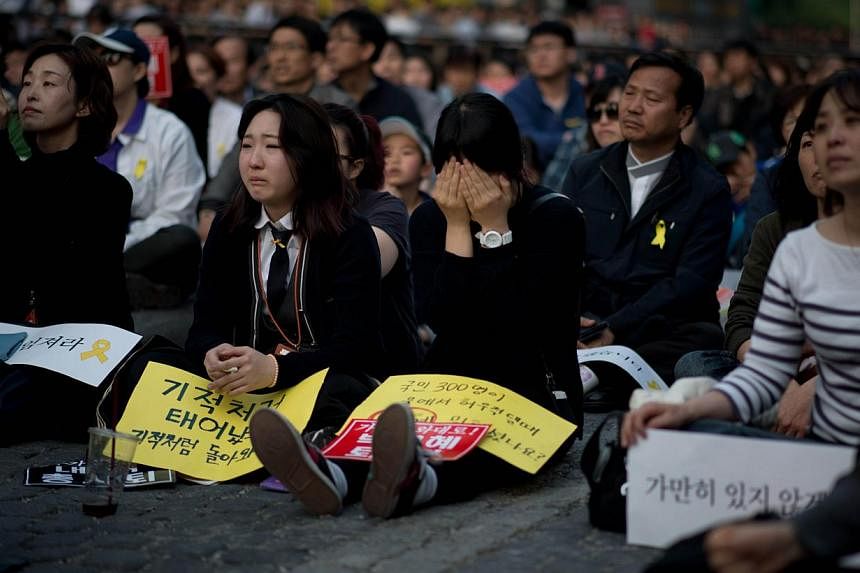 A woman weeps during a rally paying tribute to victims of the Sewol ferry disaster in Seoul on May 10, 2014. South Korea on May 11, 2014, recognised three people who died saving others in last month's ferry disaster as national "martyrs". -- FILE PHO